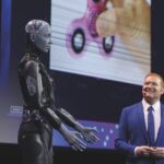 A man presenting a human-like robot at a conference