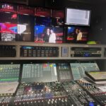 A control panel with multiple monitors in a dark room