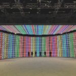A film studio with a large LED screen. Six silohuettes stand in front of it