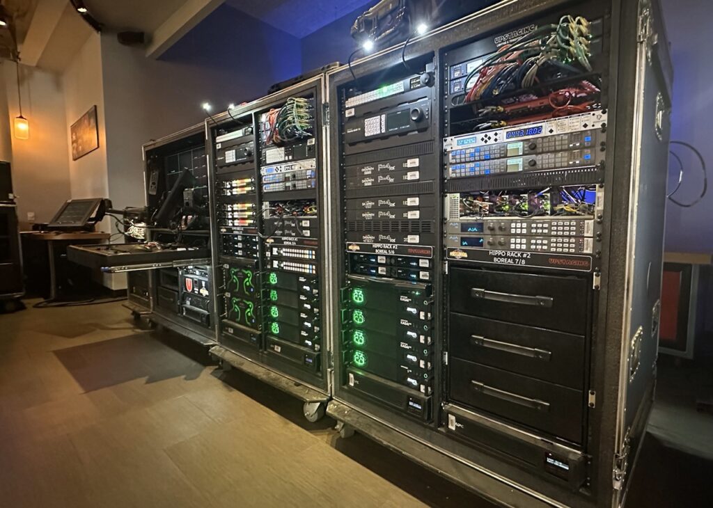 A large rack of electronic equipment in a dimly lit room