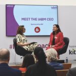 Two women sitting onstage at a conference