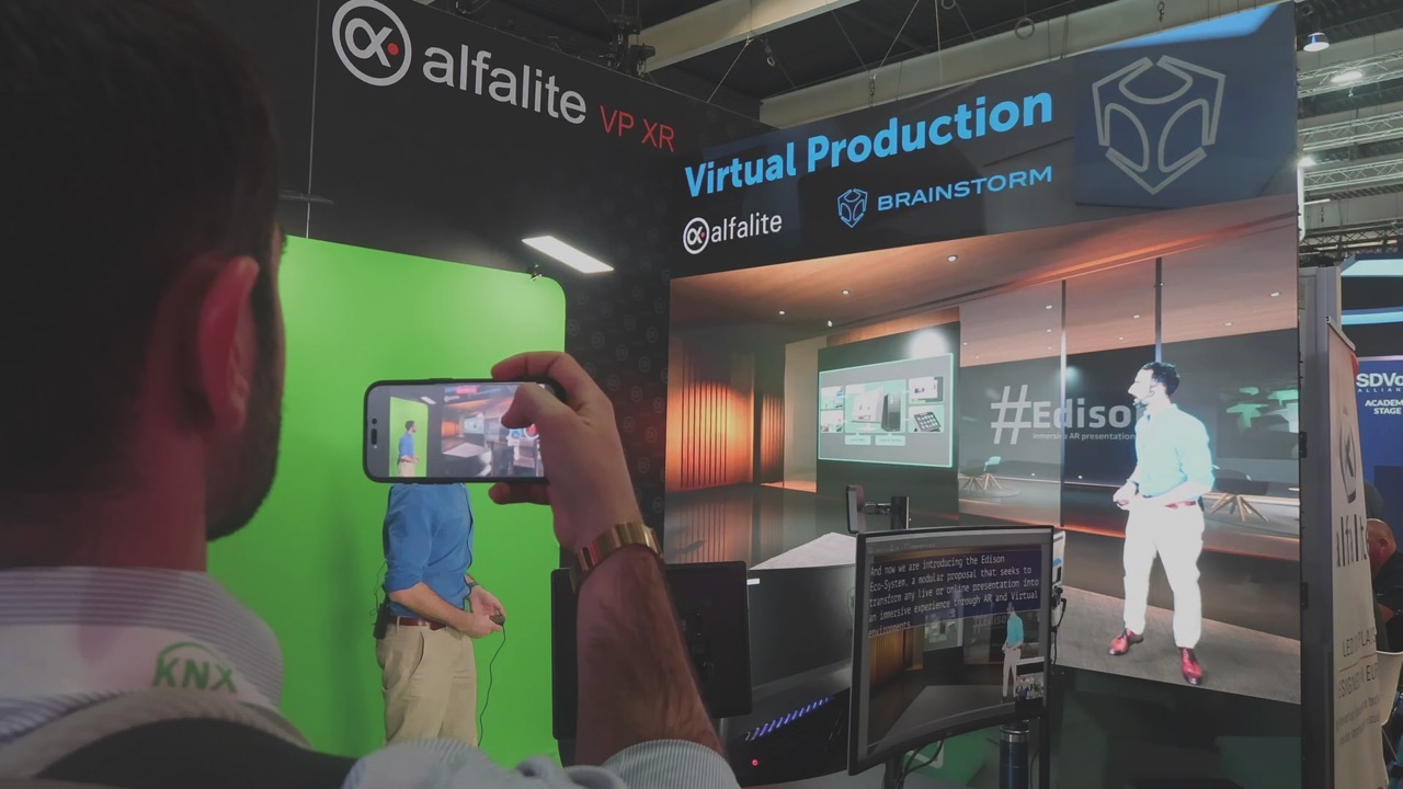 A person taking a photo on their phone of a man in a film studio