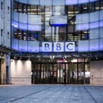 The outside the concave glass BBC building in the evening