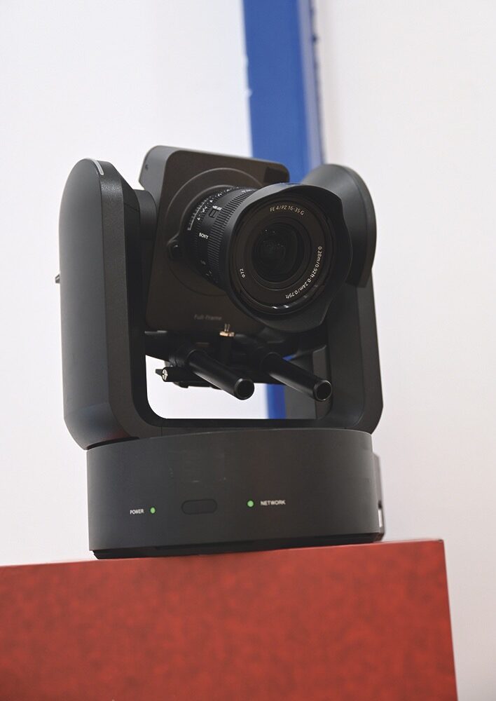 A black PTZ camera on a red stand