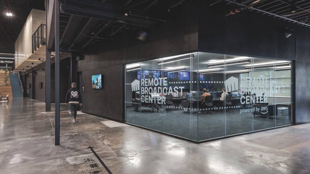 A glass room inside another room. People sit at desks in the glass room, working at computers
