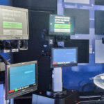 Robots on a track with screens attached prompting lines in a news room